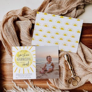 May include: A rectangular birthday invitation card featuring a yellow sun graphic with the text Our Little Sunshine Harrison Is Turning One, including event details and a photograph of a child on a beach, paired with a matching sun-patterned card.