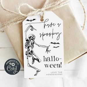 May include: White Halloween gift tag with a black skeleton dancing and bats. The tag says "Have a spooky Hallo-ween! Love the Hendersons".