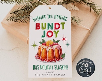 May include: A white gift tag with a red, green, and yellow illustration of a bundt cake with the text "Wishing you nothing but bundt joy this holiday season! Love, The Grant Family". The tag has a black circle with the text "Personalize with Coril" in white.