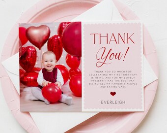 May include: A pink thank you card with the text "THANK You!" and a photo of a baby surrounded by red balloons. The card includes a message and the name "EVERLEIGH". The card is on a pink plate.