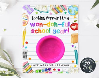 Puede incluir: Una tarjeta con temática escolar con el texto "Looking forward to a won-doh-ful school year!" y "Love Miss Williamson." La tarjeta presenta un recipiente de Play-Doh rosa, útiles escolares y un globo terráqueo.