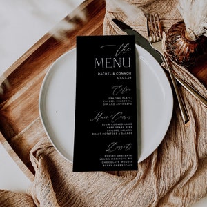 May include: A black menu card with white text. The menu card lists the menu for a wedding reception with the title "The Menu" and the names Rachel & Connor and the date 07.07.24. The menu includes appetizers, main courses, and desserts.