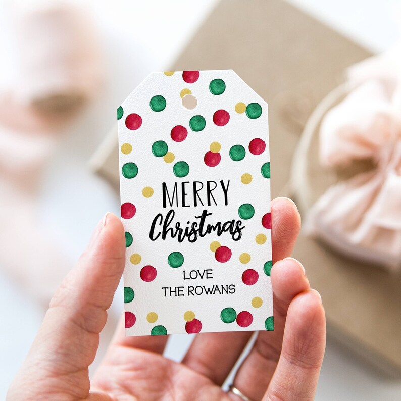 May include: White gift tag with a red and green confetti pattern. The tag says "Merry Christmas" in black script and "Love The Rowans" in black text.