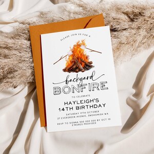 May include: A white invitation with a black and white illustration of a campfire with marshmallows on sticks. The text reads "Please join us for a backyard bonfire to celebrate Hayleigh's 14th birthday. Saturday 17th October, 27 Evergreen Avenue, Snohomish WA. RSVP to Sienna 500 000 000 by Oct 10. S'mores provided."