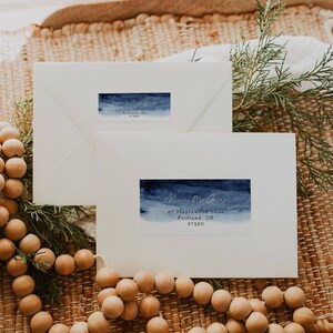 May include: Two white envelopes with blue watercolour return address labels. The top label reads "[Name] [Address] Portland, OR 97280". The bottom label reads "Alice McGuire 67 Maplewood Lane Portland, OR 97280".