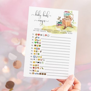 Puede incluir: Un juego de baby shower imprimible con una ilustraci&oacute;n de acuarela de un conejo sentado en un toc&oacute;n de &aacute;rbol con una pila de libros. El juego pide a los invitados que adivinen los t&iacute;tulos de los libros para ni&ntilde;os en funci&oacute;n de los emojis. El juego incluye 15 preguntas.