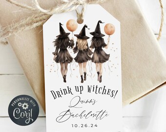 Könnte beinhalten: Ein weißer Geschenkanhänger mit drei Hexen in schwarzen Kleidern und spitzen Hüten. Sie halten orangefarbene Ballons und gehen nach rechts. Der Text auf dem Anhänger lautet "Drink up witches! Quinn's Bachelorette 10.26.24"