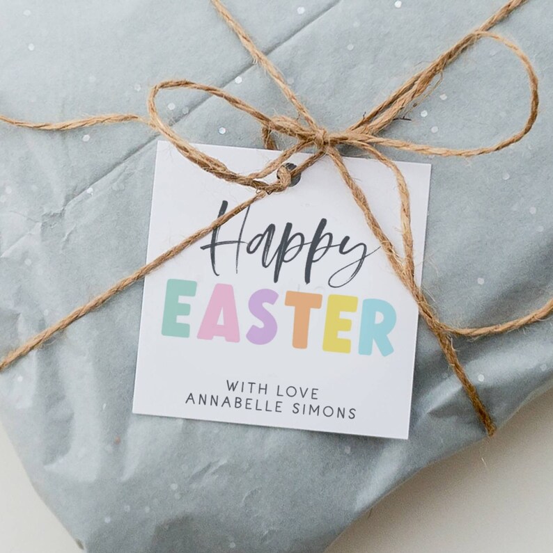 May include: A white gift tag with the text "Happy Easter" in black script with the word "Easter" in colorful block letters. The tag also includes the text "With Love Annabelle Simons".