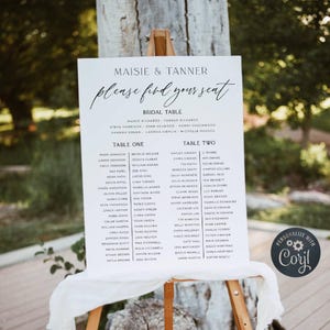 Może przedstawiać: Biała prostokątna tablica z planem stołów weselnych z czarnym tekstem Maisie & Tanner, Please find your seat, Bridal Table, Table One oraz Table Two, zawierająca listę imion pod każdym nagłówkiem, umieszczona na drewnianej sztaludze.