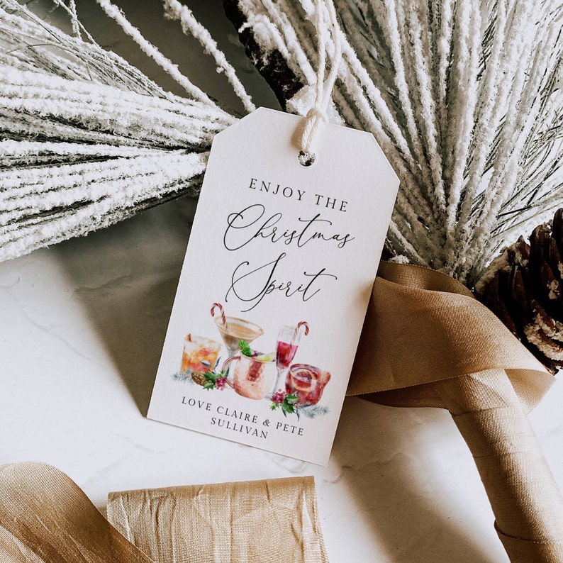 May include: White gift tag with the text "Enjoy the Christmas Spirit" in black cursive font. The tag features a watercolor illustration of holiday cocktails and the text "Love Claire & Pete Sullivan".