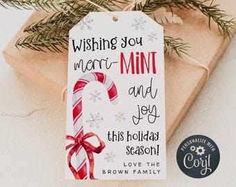 Könnte beinhalten: Ein weißer Geschenkanhänger mit einer Illustration eines roten und weißen Zuckerstabs und dem Text "Wishing you merri-MINT and joy this holiday Season! Love the Brown Family". Der Anhänger ist mit einem schwarzen Kreis personalisiert, der den Text "PERSONALIZE WITH Coril" in Weiß enthält.