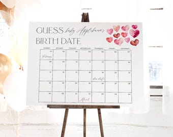 Op de afbeelding: Een witte kalender met een zwart raster en de tekst "GUESS baby Applebanas BIRTH DATE" bovenaan. De kalender is voor februari en maart en heeft een roze aquarelhartontwerp in de rechterbovenhoek.