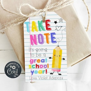 May include: A colorful gift tag with the text "TAKE NOTE" in large letters. The tag has a cartoon pencil with a smiling face and the text "It's going to be a great school year! Love Violet Adepoju".