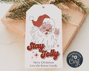 Könnte beinhalten: Ein weißer Geschenkanhänger mit einer Retro-Illustration von Weihnachtsmann mit dem Text "Stay Jolly" in roten und rosafarbenen Buchstaben. Der Anhänger enthält auch den Text "Frohe Weihnachten Liebe von der Familie Rowan" und ein personalisiertes Logo mit dem Text "Personalisieren mit Caryl".