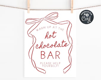 Può includere: Un cartello bianco con testo rosso e un bordo a forma di nastro. Il cartello recita "Warm up at the hot chocolate BAR. PLEASE HELP YOURSELF!" Il cartello è appeso a una corda con mollette di legno.
