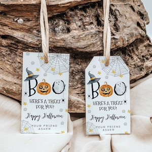 May include: Two white Halloween gift tags with black and orange illustrations of a ghost, pumpkin, and witch's hat. The text on the tags reads "BOO! Here's a treat for you! Happy Halloween Your friend Asher".