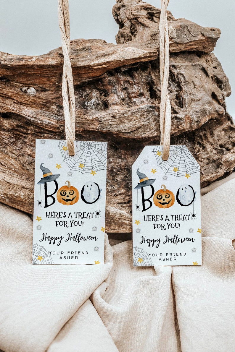 May include: Two white Halloween gift tags with black and orange illustrations of a ghost, pumpkin, and witch's hat. The text on the tags reads "BOO! Here's a treat for you! Happy Halloween Your friend Asher".