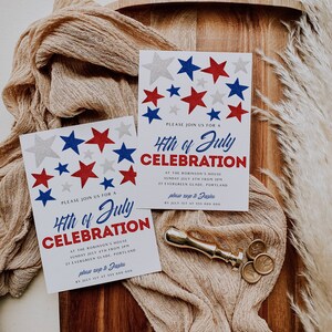 May include: Two white cards with red, white, and blue star designs and the text "4th of July Celebration" are displayed on a wooden tray with a beige cloth. A gold wax seal and stamp are also present.