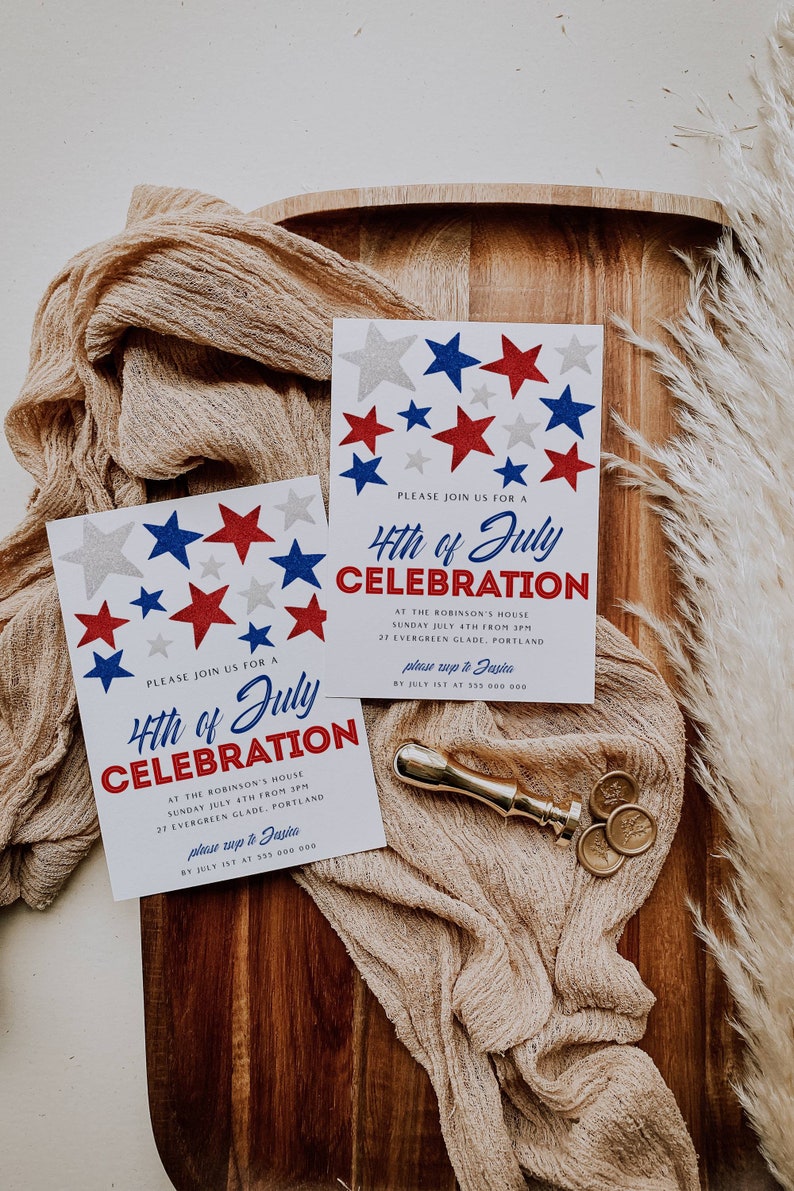 May include: Two white cards with red, white, and blue star designs and the text "4th of July Celebration" are displayed on a wooden tray with a beige cloth. A gold wax seal and stamp are also present.
