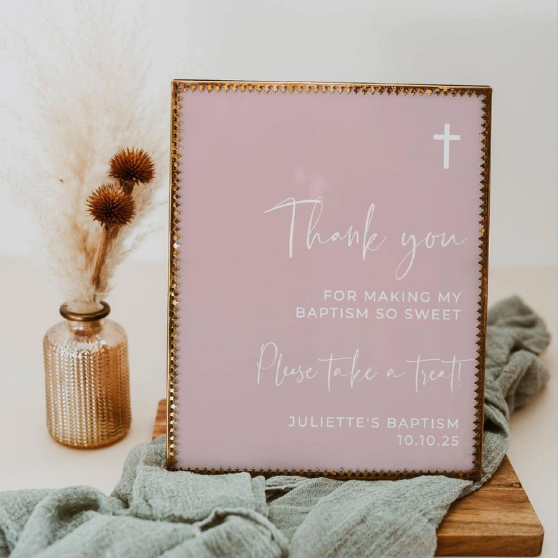 Peut inclure: Une pancarte rose avec un cadre dor&eacute; et une croix blanche en haut. La pancarte indique "Merci d'avoir rendu mon bapt&ecirc;me si doux. Prenez un petit quelque chose !" et "Bapt&ecirc;me de Juliette 10.10.25".