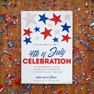 May include: A white invitation card with red, white, and blue star decorations. The text reads "4th of July Celebration" with event details. Confetti in red, blue, and white is scattered around the card on a wooden surface.