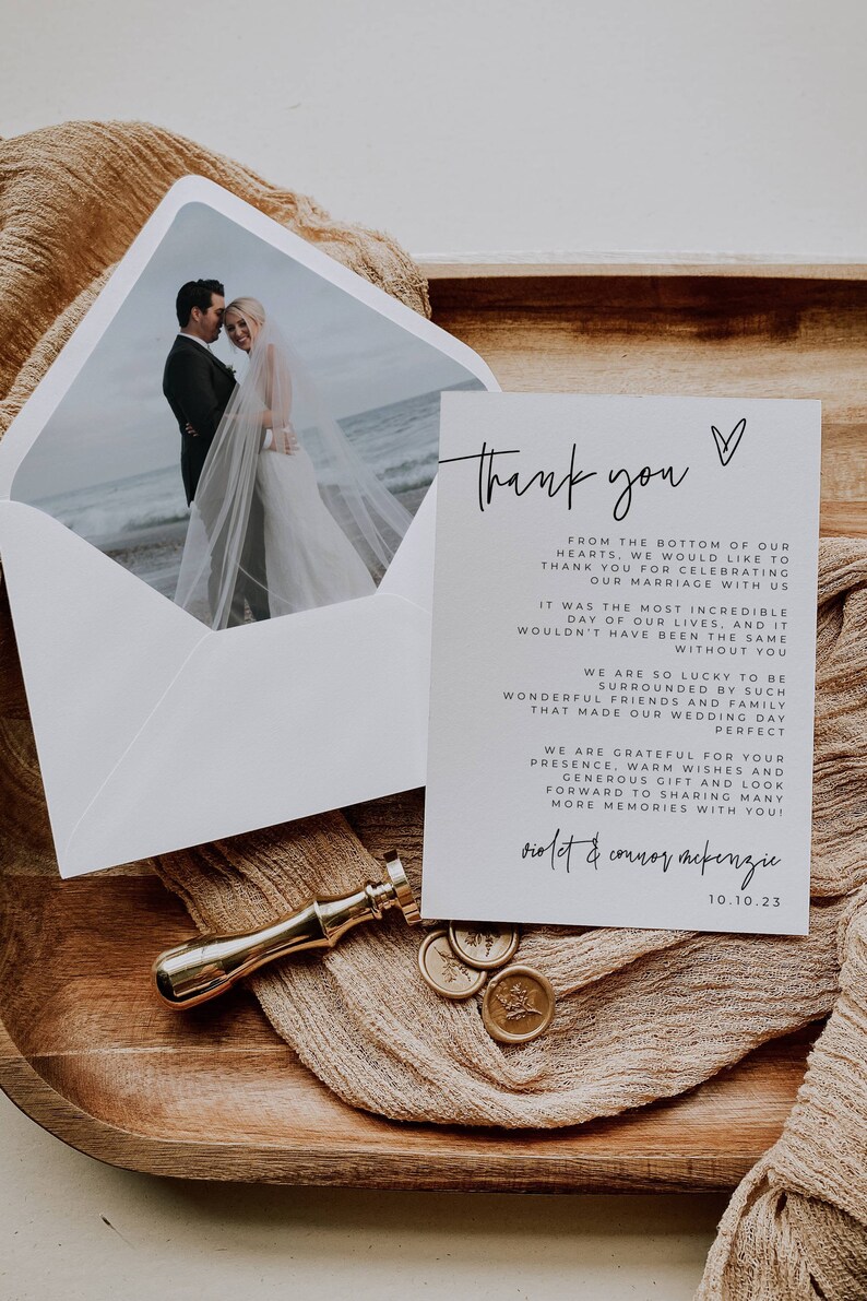 May include: A white thank you card with black text. The text reads "Thank you ♡ From the bottom of our hearts, we would like to thank you for celebrating our marriage with us. It was the most incredible day of our lives, and it wouldn't have been the same without you. We are so lucky to be surrounded by such wonderful friends and family that made our wedding day perfect. We are grateful for your presence, warm wishes and generous gift and look forward to sharing many more memories with you! Violet & Connor McKenzie 10.10.23"