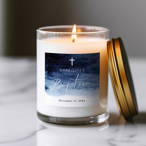 May include: A white candle with a blue watercolor design label. The label says "Harrison's Baptism" with a cross and the date "November 17, 2024".