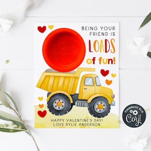 May include: A Valentine's Day card with a yellow dump truck and a red bowl. The card reads "BEING YOUR FRIEND IS LOADS of fun!" and "HAPPY VALENTINE'S DAY! LOVE RYLIE ANDERSON."