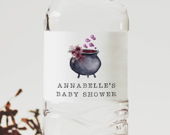 Könnte beinhalten: Wasserflaschenetikett mit einem schwarzen Kessel mit lilafarbenem Zaubertrank und Blumen sowie dem Text "Annabelle's Baby Shower".