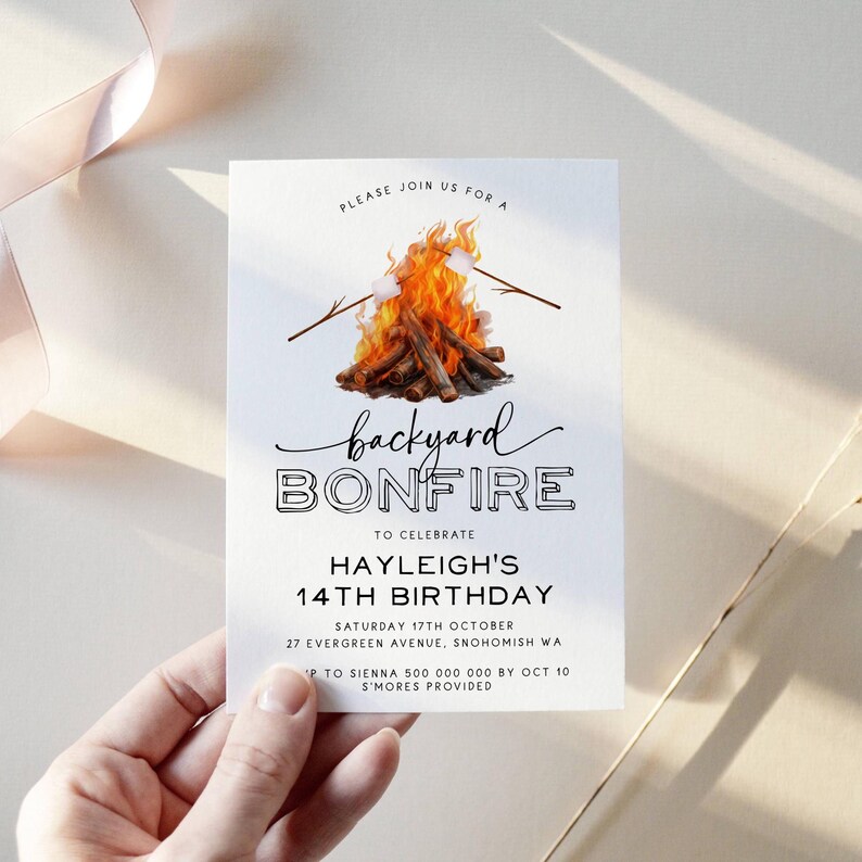 May include: A white invitation with black text for a backyard bonfire party to celebrate a 14th birthday. The invitation features a watercolor illustration of a campfire with marshmallows on sticks. The text reads "Please join us for a backyard bonfire to celebrate Hayleigh's 14th birthday. Saturday 17th October, 27 Evergreen Avenue, Snohomish WA. RSVP to Sienna 500 000 000 by Oct 10. S'mores provided."