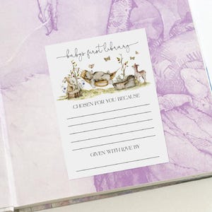 Pu&ograve; includere: Un biglietto bianco con un'illustrazione ad acquerello di un orso in un'amaca con farfalle e un cervo. Il biglietto dice "baby's first library" e ha righe per scrivere "scelto per te perch&eacute;" e "dato con amore da".