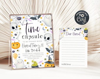 May include: A Halloween-themed time capsule gift set. The clear box features a design with ghosts, bats, pumpkins, and the text "Time Capsule" and "Harriet Turns 18 in 2044." A matching lined card is included.