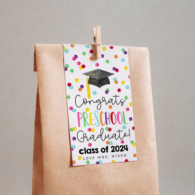 Puede incluir: Una tarjeta blanca con un patr&oacute;n de confeti colorido y una gorra de graduaci&oacute;n negra. La tarjeta dice "Congrats Preschool Graduate! Class of 2024 Love Mrs. Ryder".