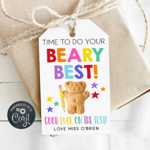 May include: A white gift tag with the text "TIME TO DO YOUR BEARY BEST!" in colorful letters. A teddy bear illustration and a pencil are featured. The tag also includes the text "GOOD LUCK ON THE TEST!" and "LOVE MISS O'BRIEN".