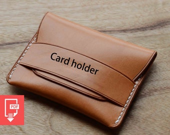 May include: A brown leather card holder with white stitching. The card holder has a flap with the text "Card holder" embossed on it.
