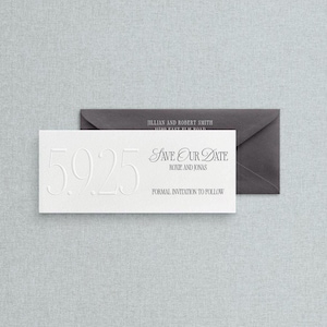 May include: A white embossed 'Save Our Date' card with the date '5.9.25' and the text 'Save Our Date' with names 'Roxie and Jonas'. A dark gray envelope is behind the card. The text 'Formal invitation to follow' is also present.