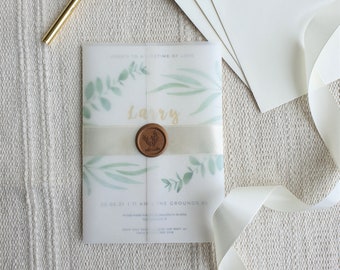 Puede incluir: Una invitación blanca con un diseño de acuarela de hojas verdes y una cinta dorada. La invitación dice "Here's to a lifetime of love" y "Larry" en letras doradas. Un sello de cera marrón con un diseño de hoja está en la cinta.