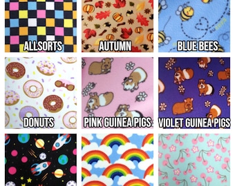 May include: Nine fabric swatches with various patterns. Designs include colorful checkerboard, autumn leaves, bees, donuts, guinea pigs, space rockets, rainbows, and cherry blossoms. Each swatch has a text label.