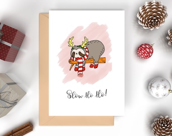 May include: A Christmas card featuring a cartoon sloth wearing a red and white scarf and reindeer antlers. The sloth is sleeping on a branch and the card says "Slow Ho Ho!"