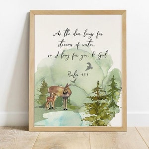 Könnte beinhalten: Ein Aquarelldruck mit grünem und blauem Hintergrund, der eine Mutter und ein Junges in einer Waldlandschaft zeigt. Der Druck enthält den Text "Wie der Hirsch schreit nach frischem Wasser, so verlangt meine Seele nach dir, Gott. Psalm 42:1."