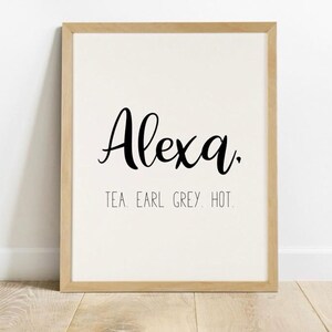 May include: A framed print with the name "Alexa" written in cursive script. The text "Tea. Earl Grey. Hot." is written below the name.