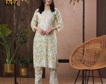 May include: A white and green floral print kurta and palazzo set. The kurta has a round neckline and three-quarter sleeves. The palazzo pants have a straight leg.