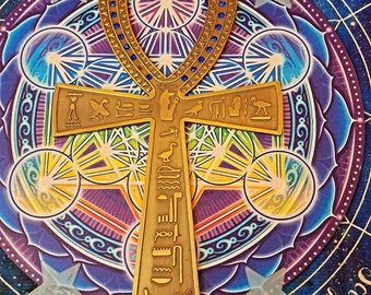 May include: A gold-colored Ankh pendant with blue accents, set against a colorful mandala background with stars. The Ankh is a symbol of life and eternal life in ancient Egyptian culture.
