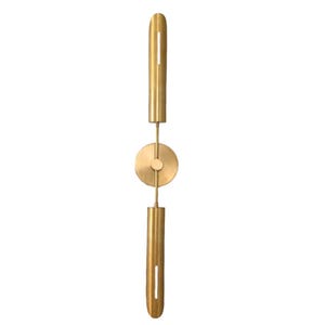May include: A gold metal wall sconce with a circular design in the middle. The sconce has two vertical sections that are connected by the circular design.