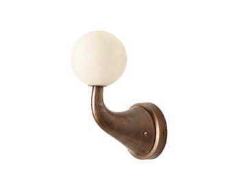 May include: A wall-mounted light fixture with a spherical, off-white glass shade. The fixture has a curved, bronze-colored arm and a circular base. The design is simple and elegant, suitable for various interior styles.