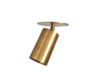 May include: A gold-colored, cylindrical ceiling spotlight with a circular mounting plate. The light fixture is angled, showcasing its adjustable design. The metallic finish adds a modern touch to the lighting fixture.