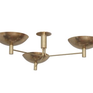 May include: A brass ceiling light fixture with three bowl-shaped shades and a central stem.