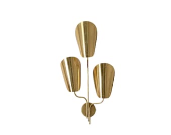 May include: A gold-colored wall sconce with three tulip-shaped shades. The sconce has a circular base and curved arms supporting the shades. The design is symmetrical and modern, suitable for interior lighting.