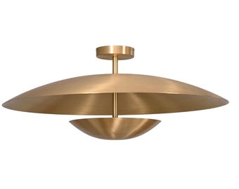 May include: A brushed brass ceiling light fixture featuring a large, shallow, disc-shaped shade positioned above a smaller, bowl-shaped component. The two pieces are connected by a central vertical rod attached to a circular ceiling mount.
