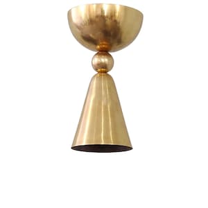 May include: A gold-toned ceiling light fixture with a round, bowl-shaped top and a cone-shaped bottom.